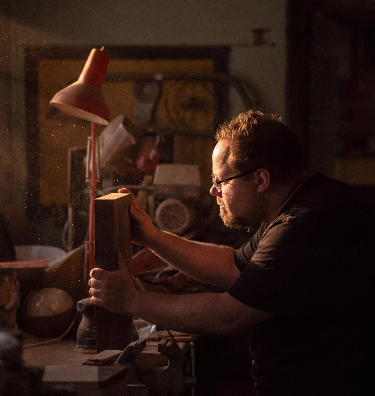 Craftsman inspecting a wooden board by hand in the workshop